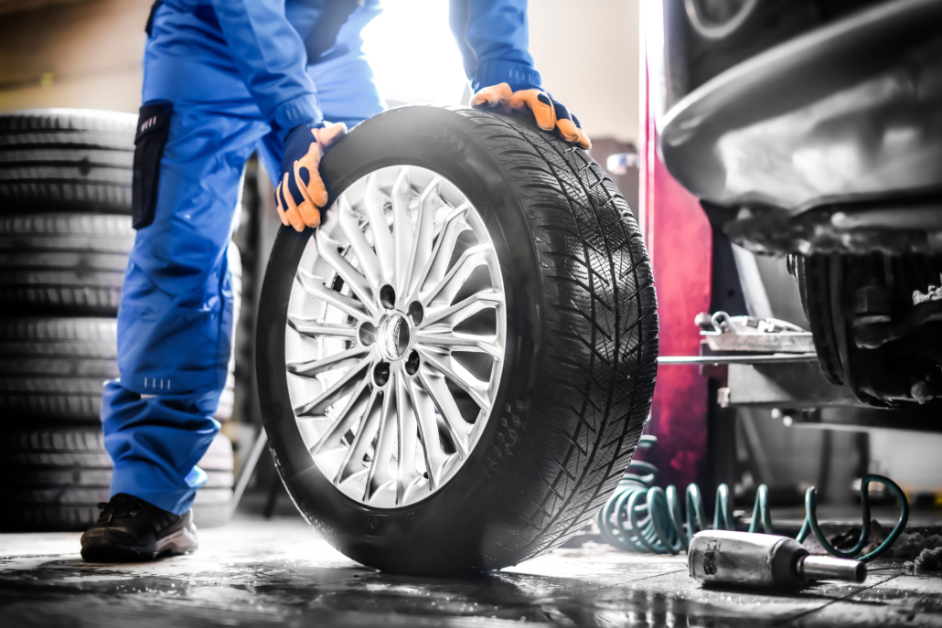 Car,Mechanic,Working,In,Garage,And,Changing,Wheel,Alloy,Tire. byta däck