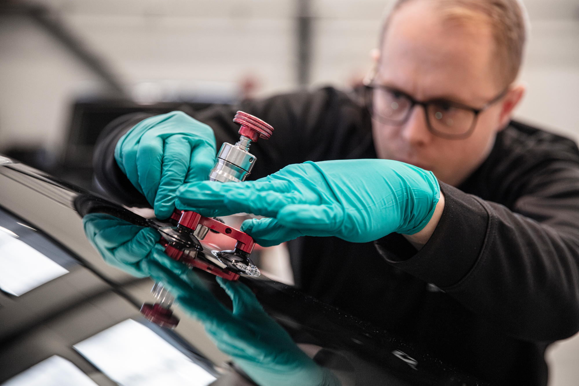 stenskott v3 En man som lagar ett stenskott på en vindruta med ett verktyg